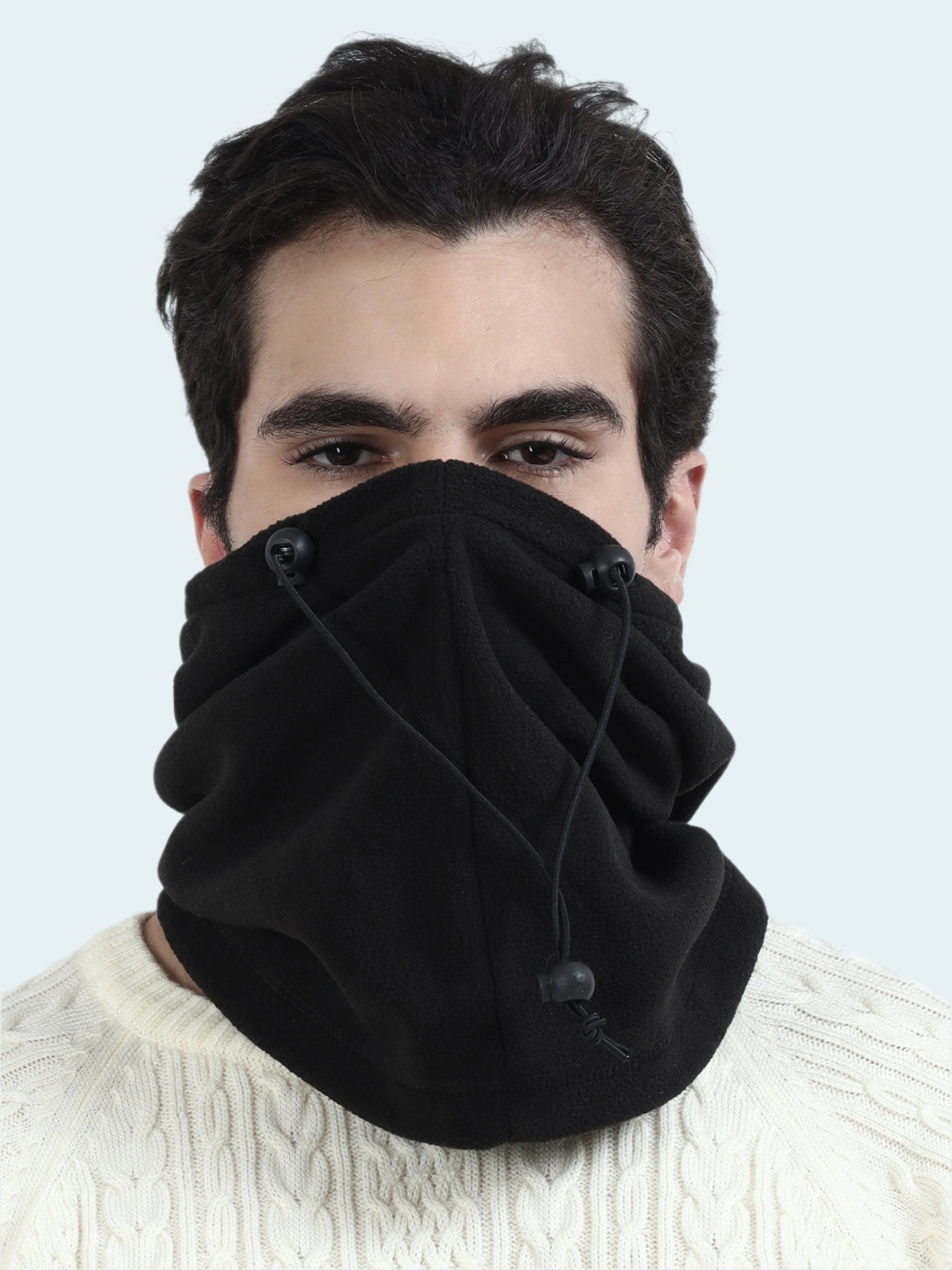 Person wearing a black balaclava with buttons on a white background