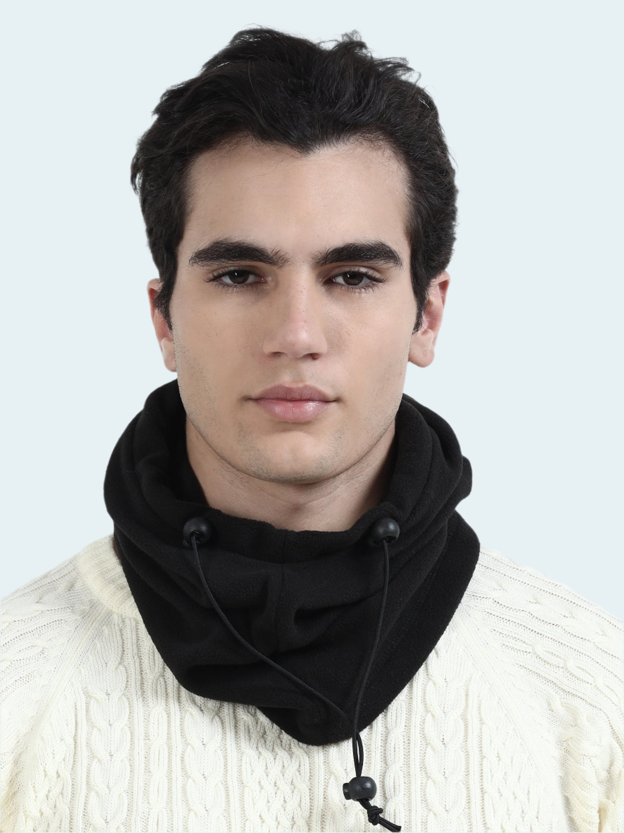 Man wearing a black balaclava and white sweater against a white background