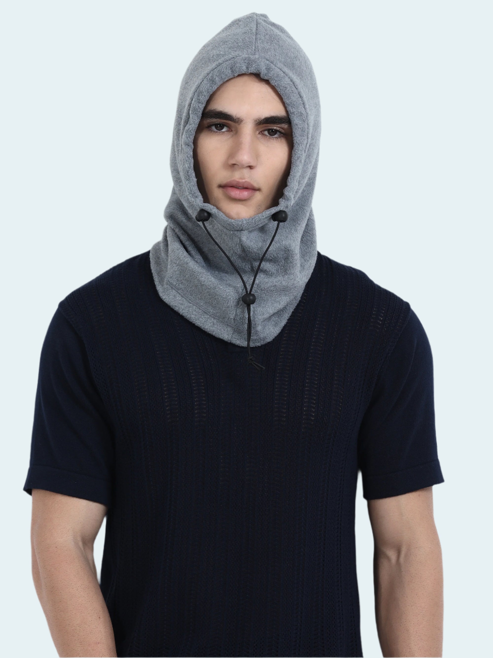 Person wearing a gray hooded balaclava against a white background