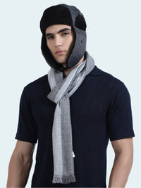 Man wearing a dark shirt and gray scarf with a black and gray trapper hat on a white background