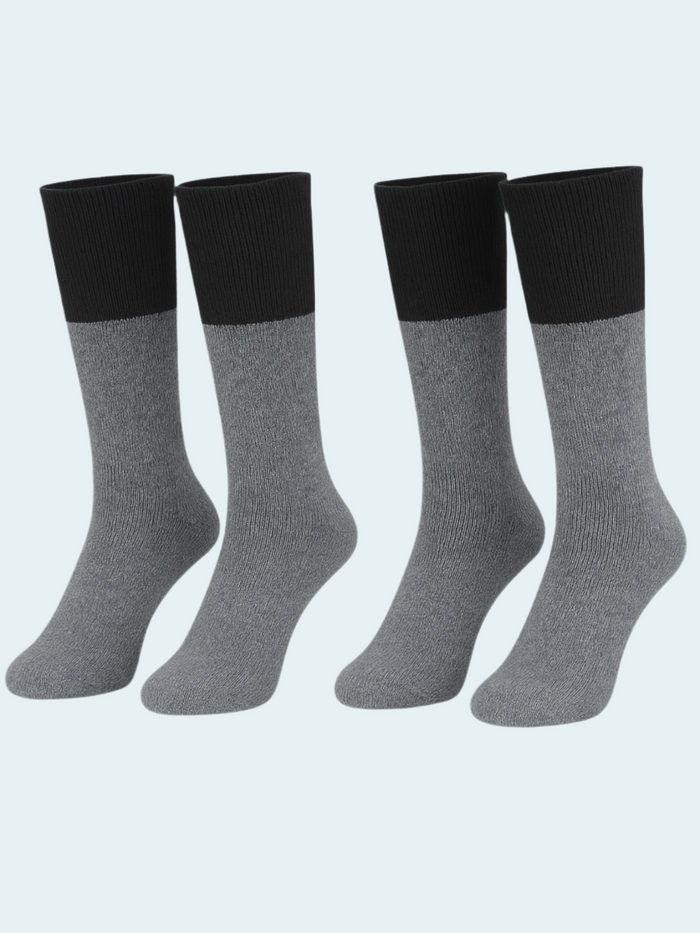 Four pairs of gray socks with black tops on a light gray background
