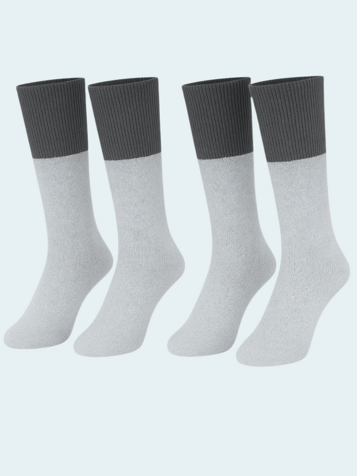 Four pairs of gray socks with black cuffs on a light blue background