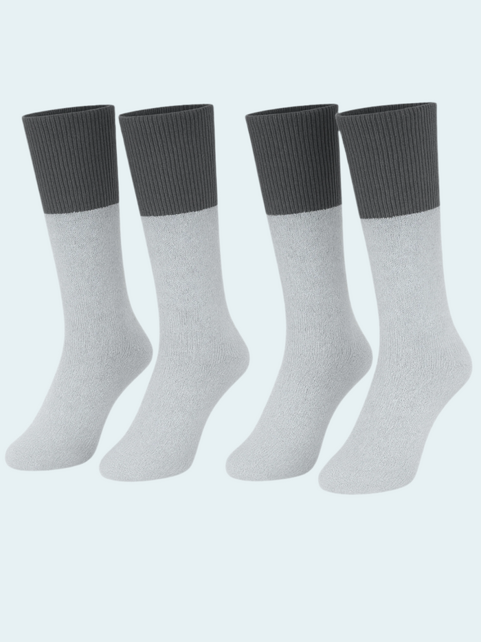 Four pairs of gray socks with black cuffs on a light blue background