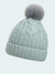 Knitted beanie with a gray pom-pom on a light blue background