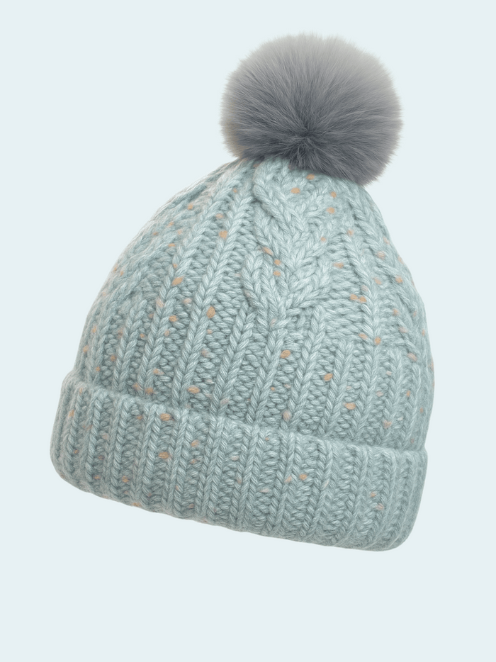 Knitted beanie with a gray pom-pom on a light blue background