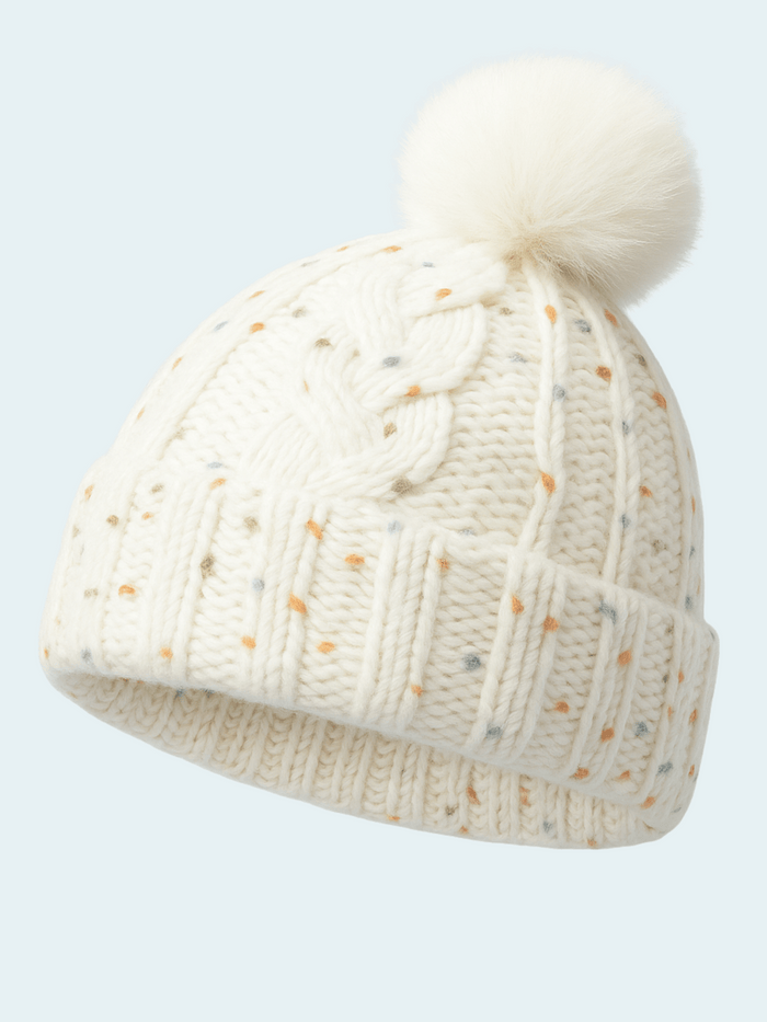 Knitted beanie with a pom-pom on a light gray background