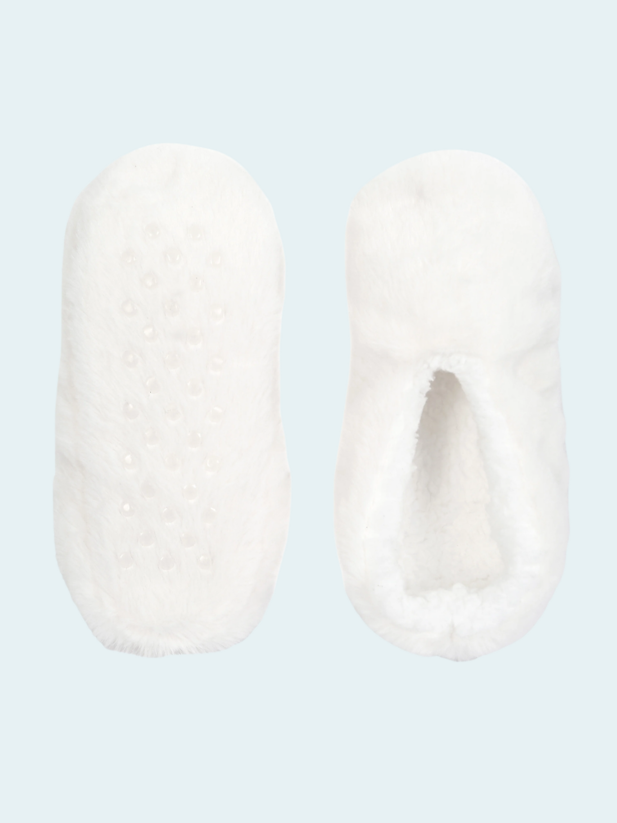 Pair of white slipper socks on a light blue background
