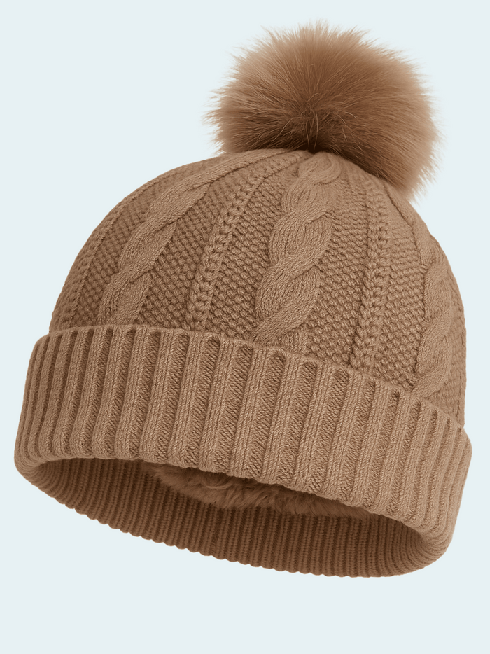 Brown knit beanie with a pom-pom on a light gray background